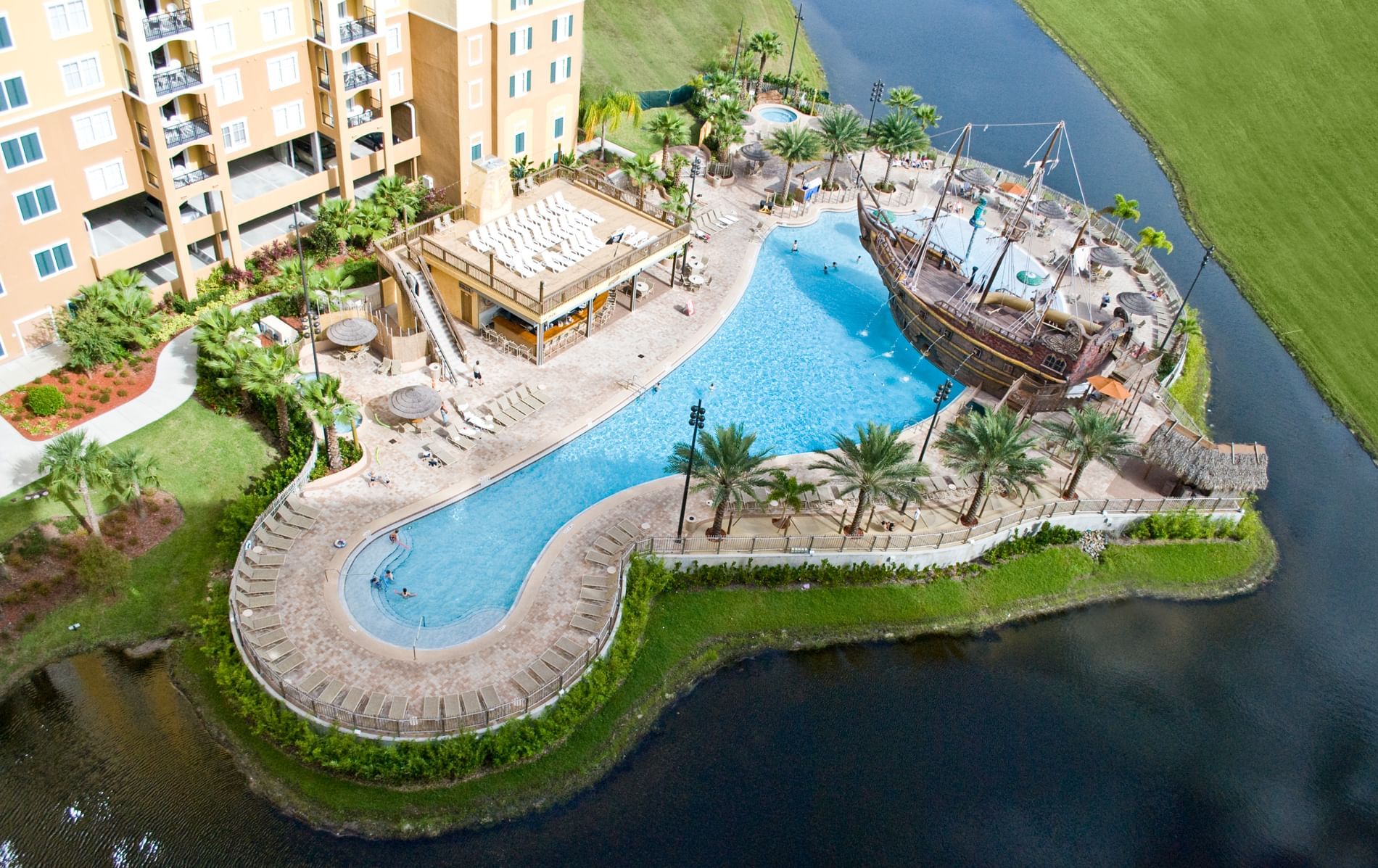 An aerial view of a resort pool with a ship themed area