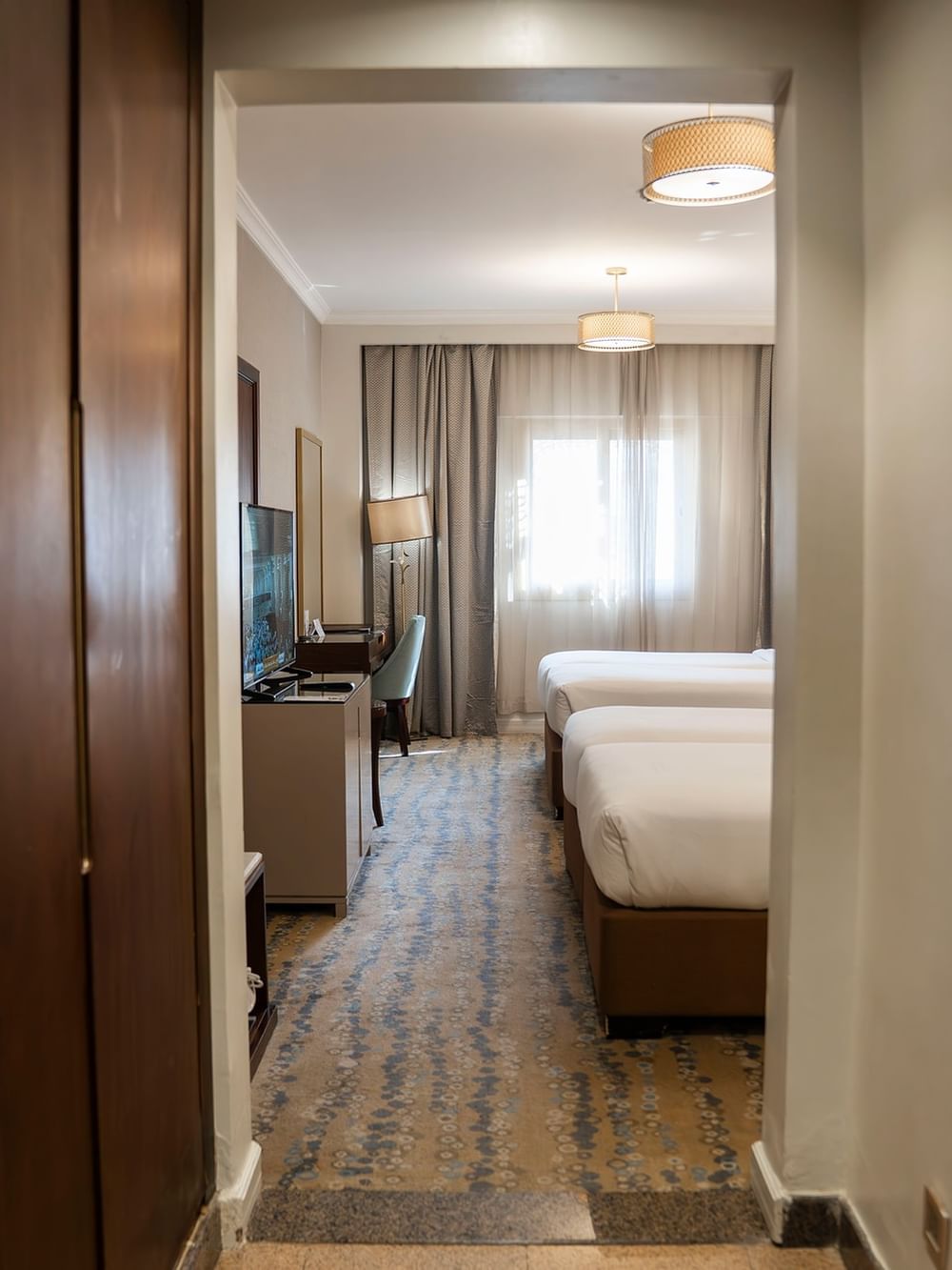 غرفة توأم تنفيذية مزودة بسريرين وتلفزيون ونافذة في فندق سجى ورويك المدينة المنورة.