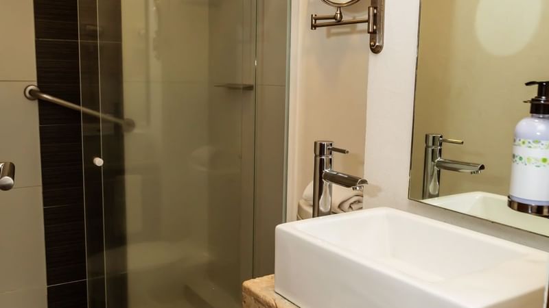 Bathroom vanity with amenities and shower area in a room at Gamma Puebla Senorial Centro