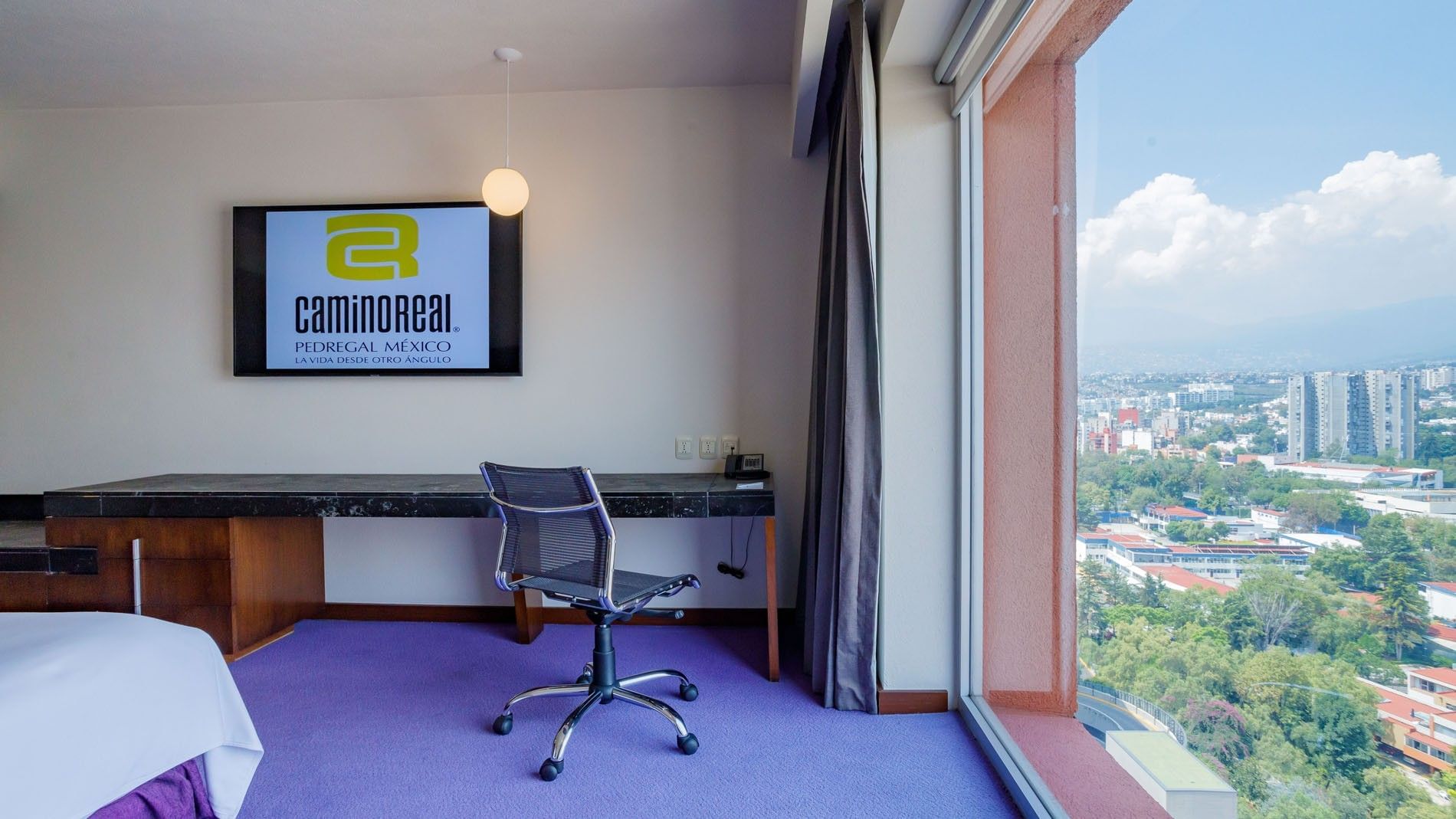 Work desk in King Camino Real Club featuring scenic city view window at Camino Real Pedregal Mexico