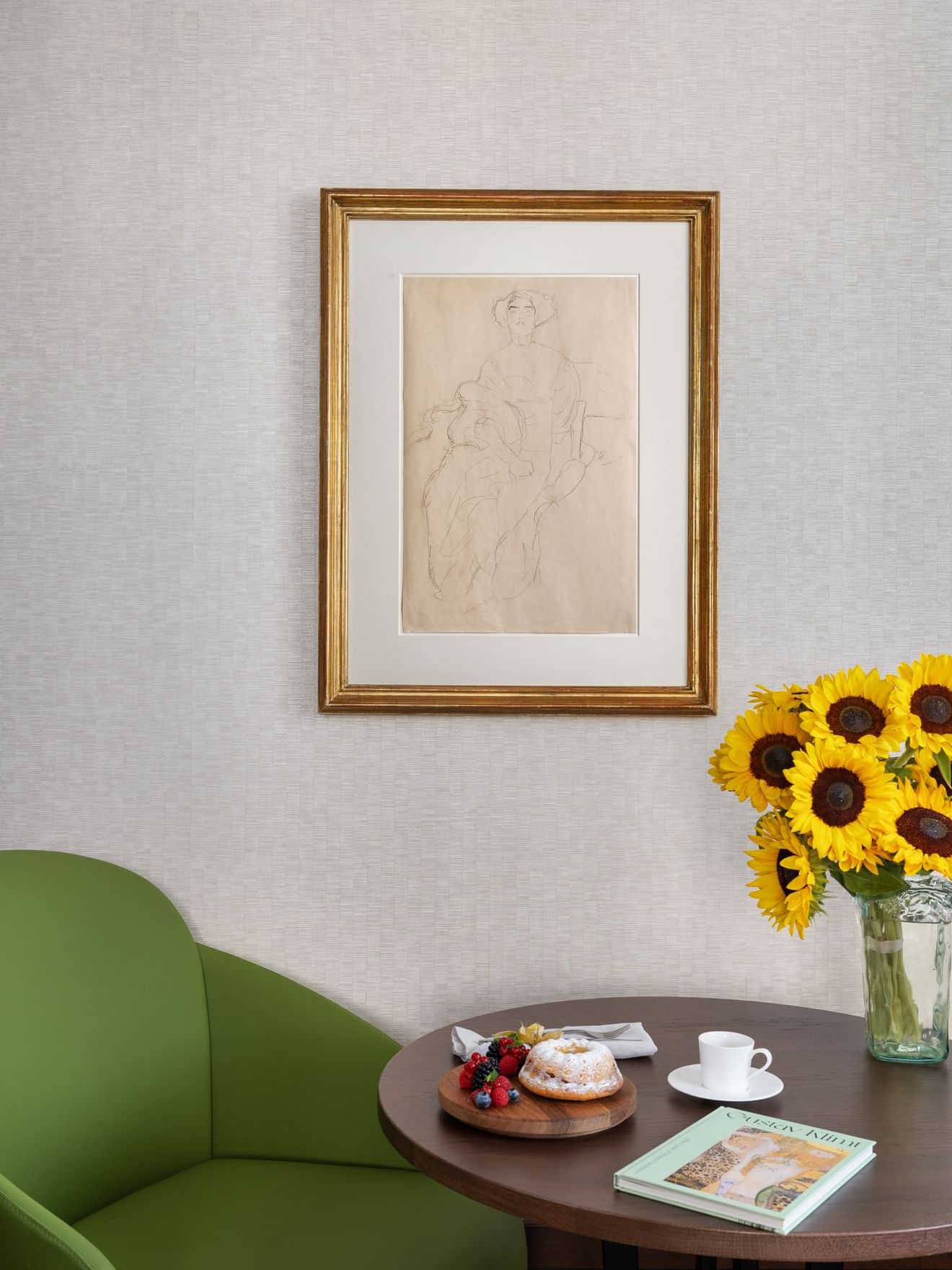 Framed sketch on a wall by a vase of sunflowers in Klimt-Suite at Almanac Palais Vienna