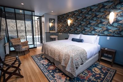 Cómoda cama y sillón estampado en una habitación de The Aubrey Hotel, un hotel boutique en Santiago de Chile