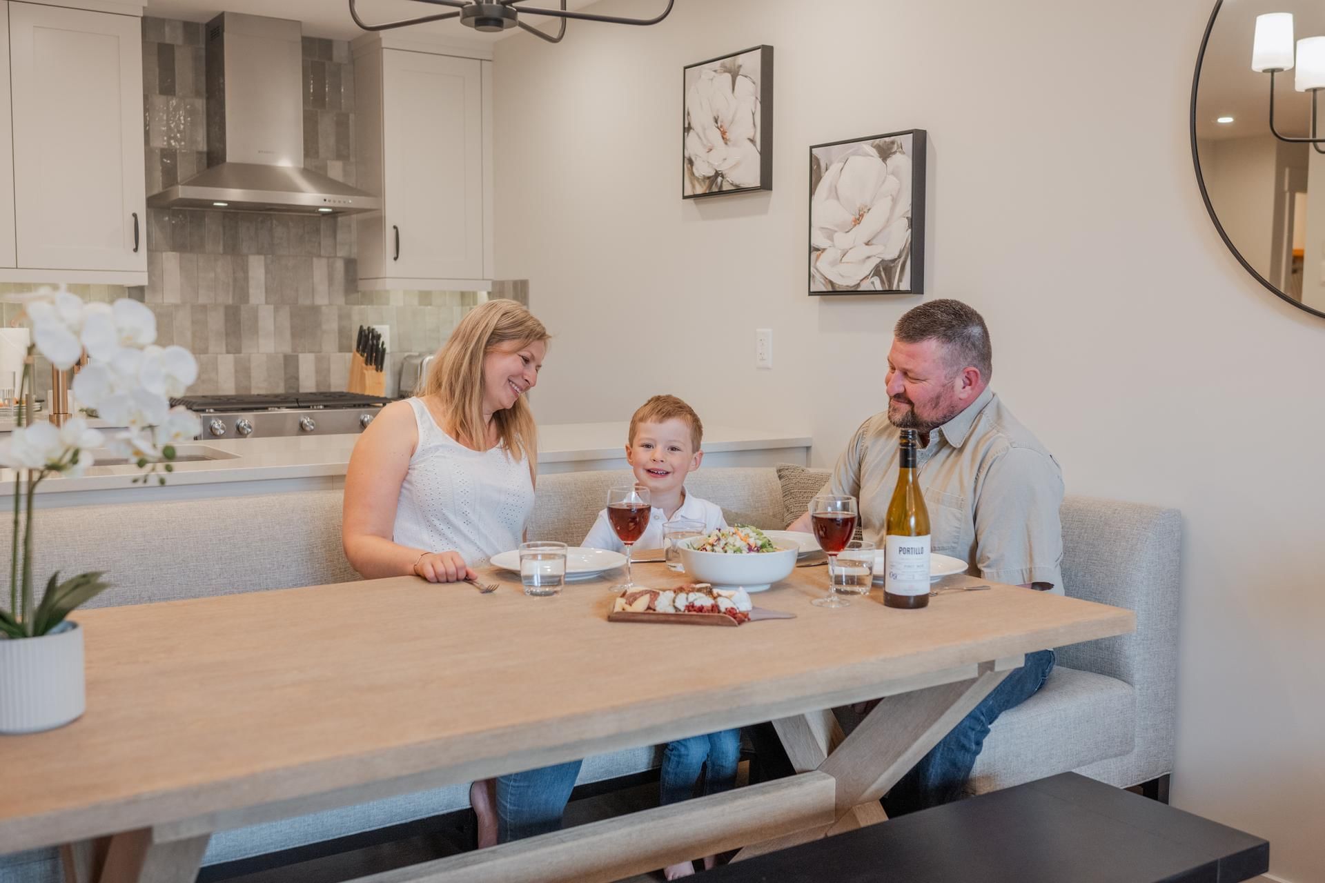 Family enjoying a meal with food and drinks in a modern kitchen at Spring Creek Vacations