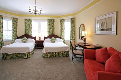 two beds and red couch in hotel room