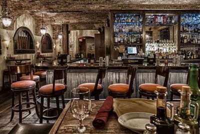 Arranged chairs by the bar counter in Trattoria Romana at Ocean Lodge Boca Raton