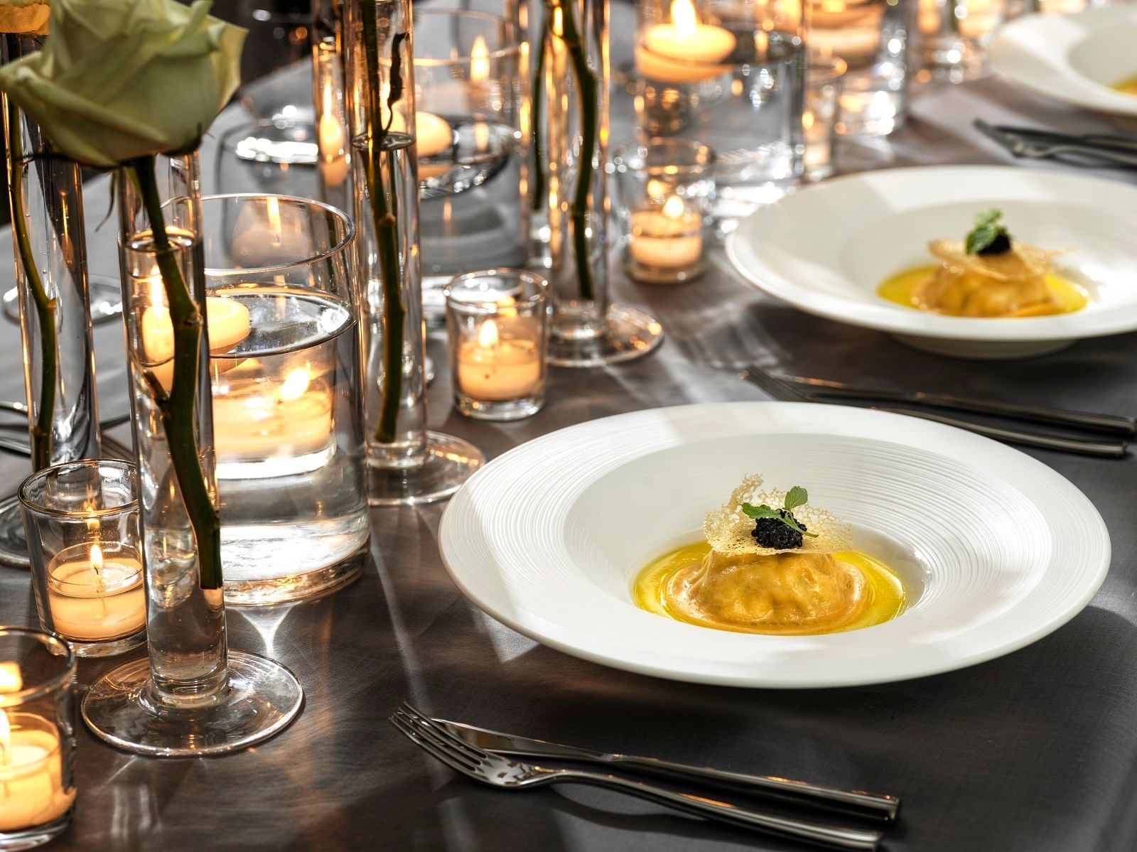 Breakfast served by a row of candles at The Londoner Hotel