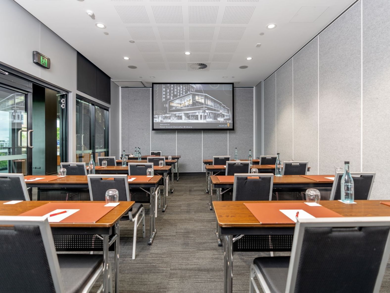 Classroom-style conference room in Brisbane with presentation screen, desks, and modern meeting facilities at Hotel Grand Chancellor Brisbane.
