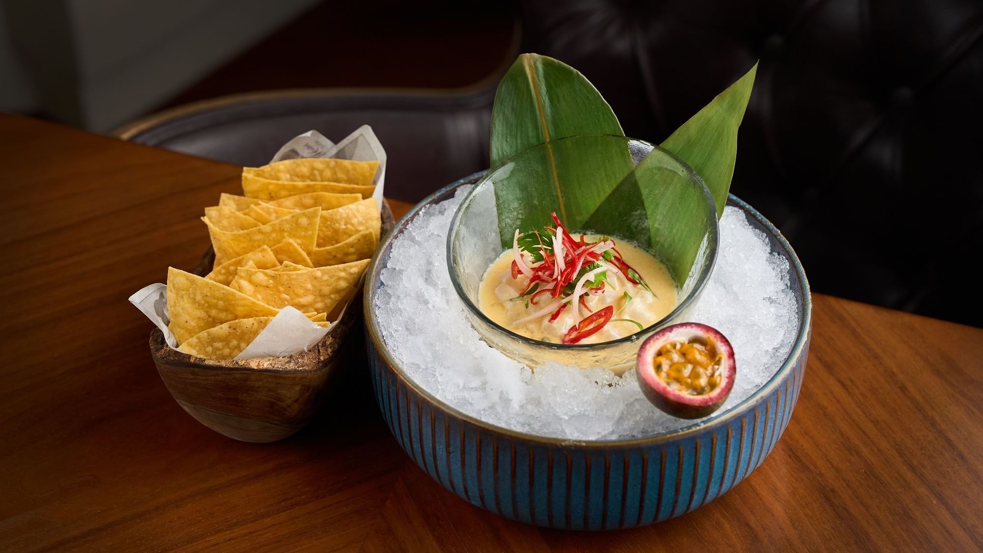 A bowl of soup with passion fruit and chips served in Pacific Groove Restaurant & Lounge at Paramount Hotel Dubai