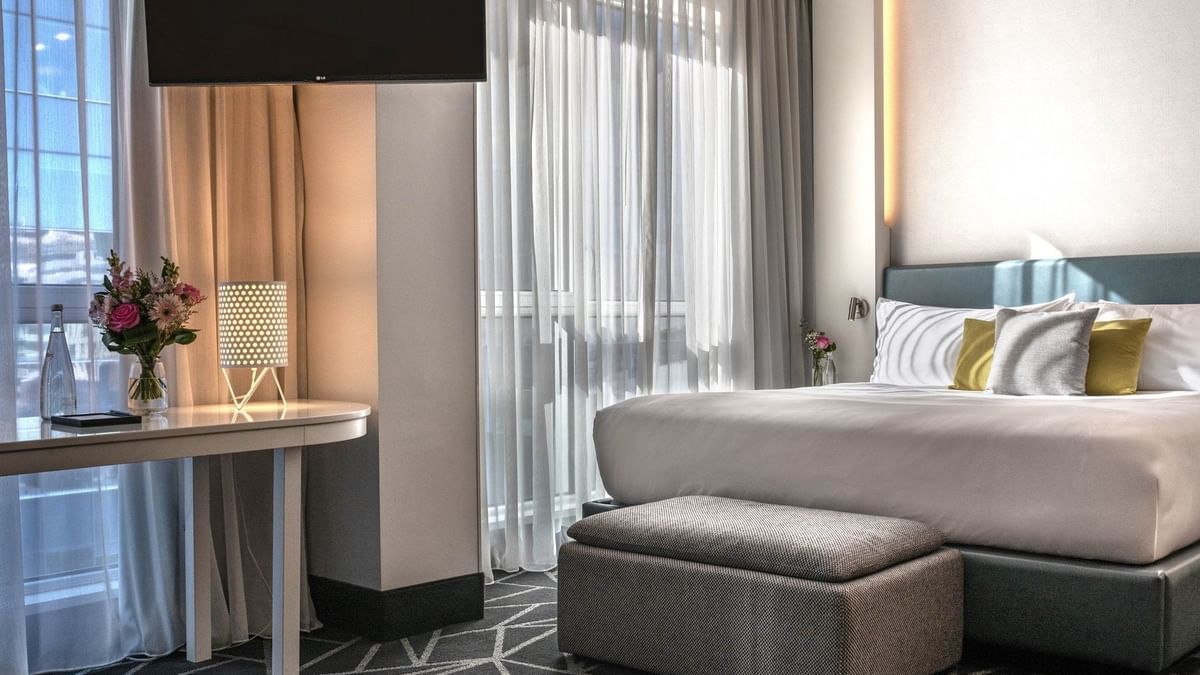 Suite Loft élégamment aménagée, dotée d'un grand lit et d'une décoration moderne, au Warwick Le Crystal Montréal.