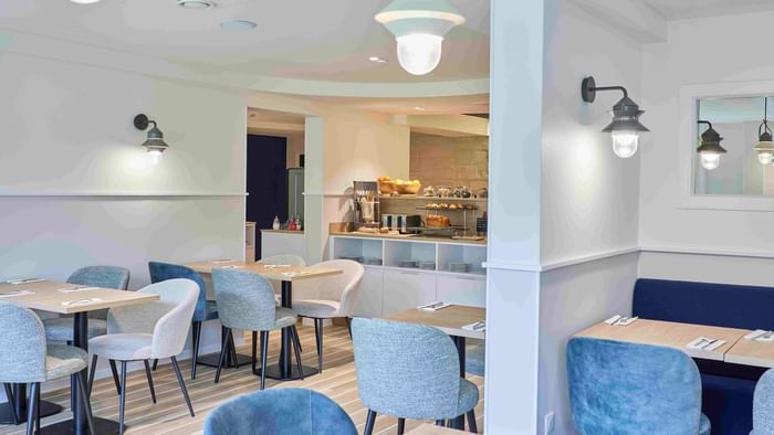 Salle à manger élégante avec tables et chaises bleues à l'Hôtel La Marébaudière.