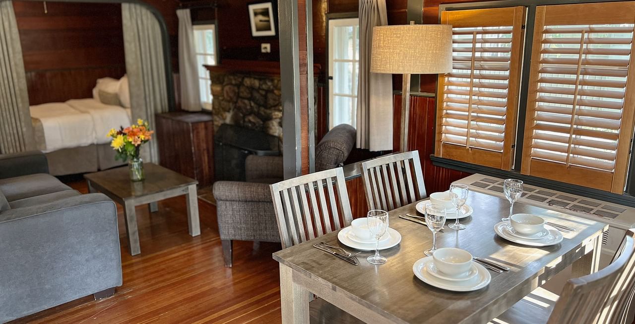 Interior of cabin with dining area, bed, and sitting area