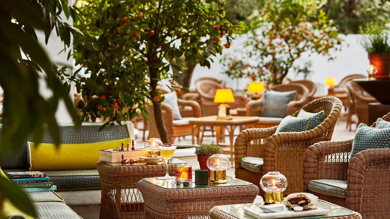 Wicker seating with pillows placed under the orange tree at the Marbella Club