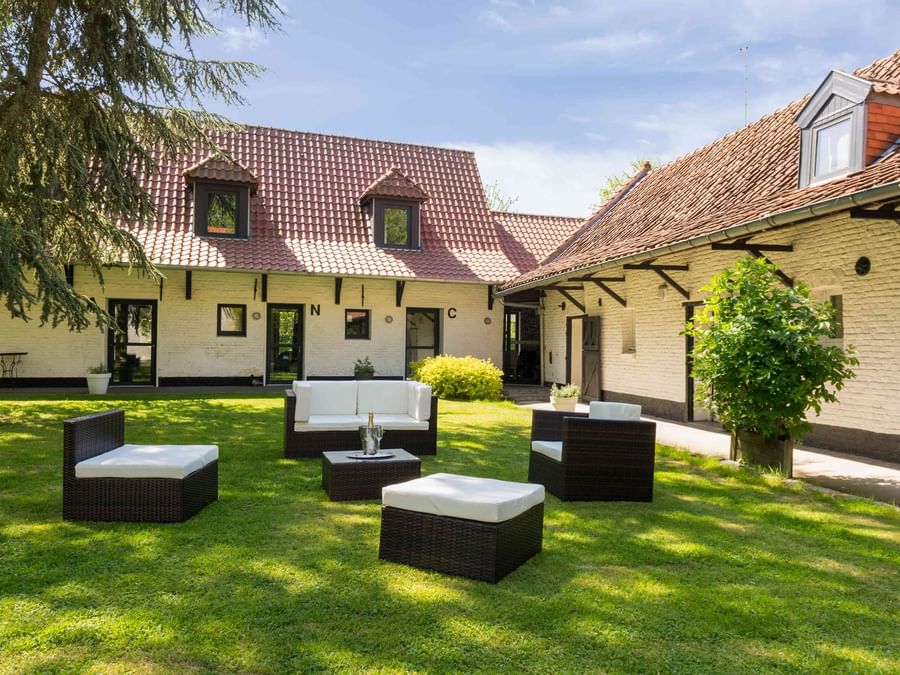 An outdoor lounge area by the lawn at La Ferme Blanche