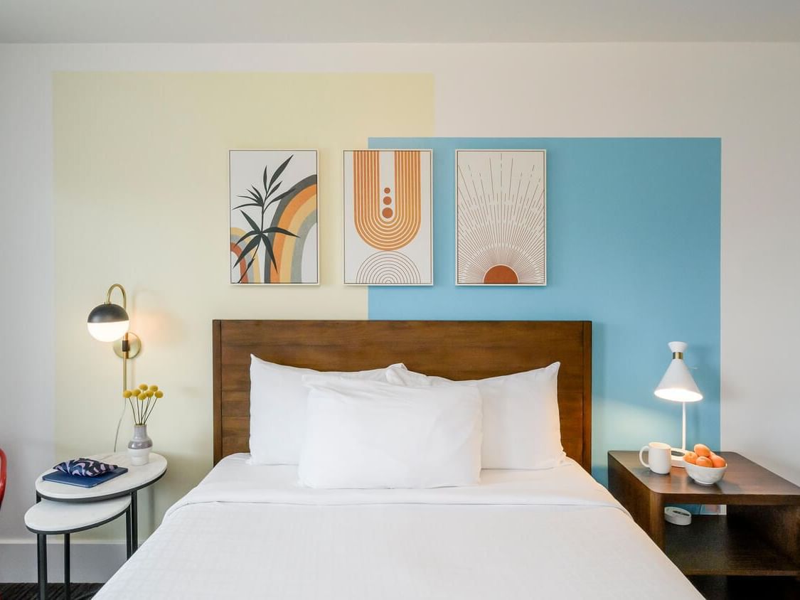 Bed and nightstands with wall art in Superior Queen Room at Becks Motor Lodge