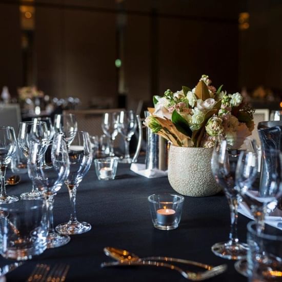 Flowers, glasses & candles on a table at Pullman Olympic park 