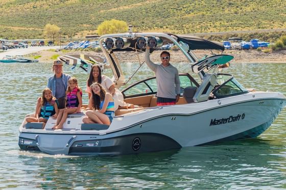 A family enjoying a boat ride on a sunny day near Stein Eriksen Lodge