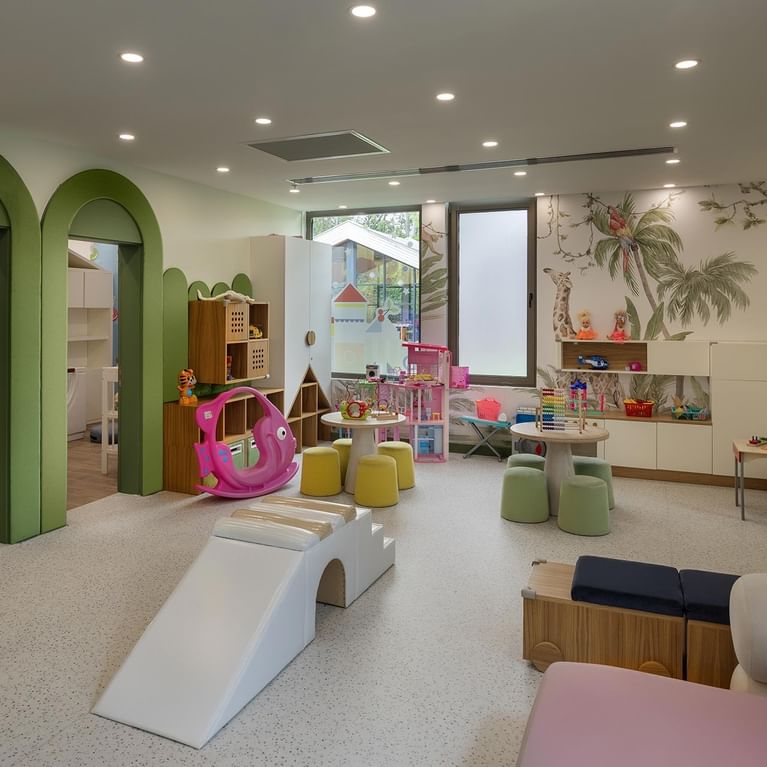 Яркая игровая комната с красочными игрушками и зелеными арками в Upupa Kids Club в Cullinan Belek, Анталья