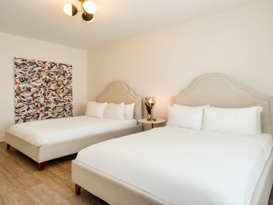 Bedroom double with two beds, upholstered headboards, and modern artwork at Kenmore Village Hotel South Beach