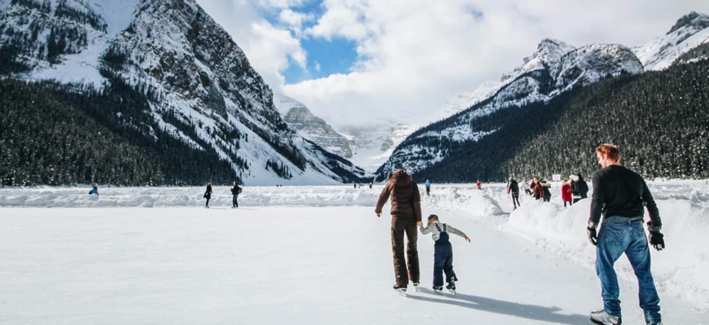 family ice skates on a lake near Canmore