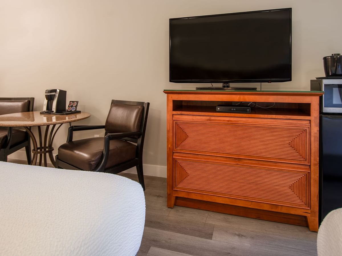 Hotel guestroom with two queen beds, TV, microwave, mini fridge, table and chairs