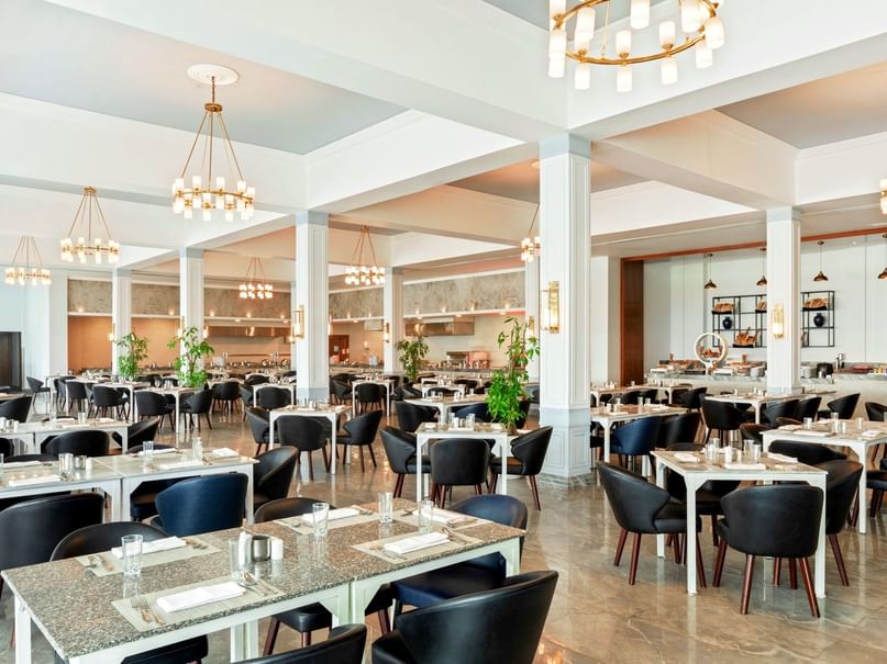 Elegant dining area with tables and chairs under chandeliers at Pickalbatros Palace Hotel in Red Sea Governorate.