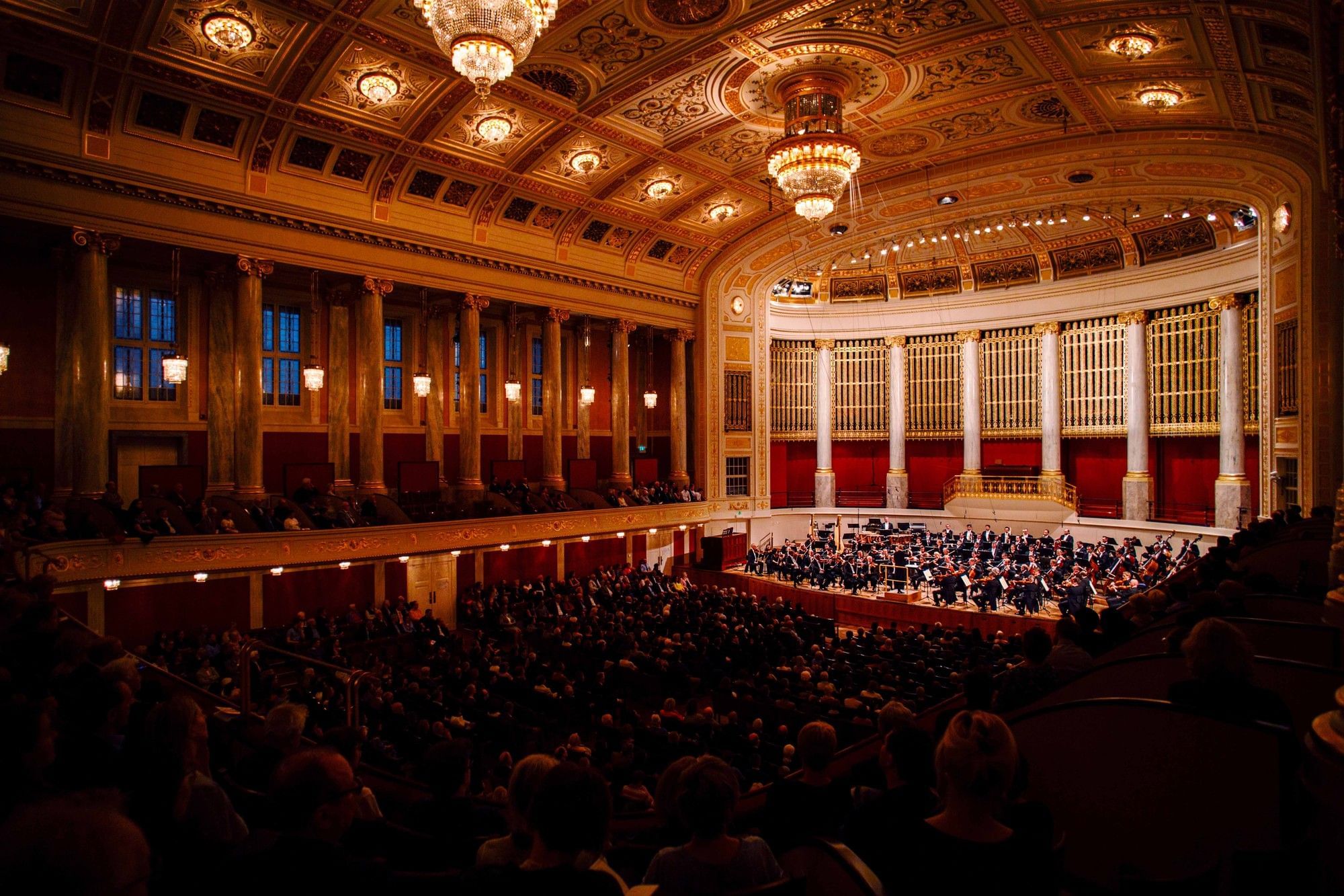 Konzert im Wiener Konzerthaus mit Orchester, Publikum und prunkvollem Saal in warmer Lichtstimmung