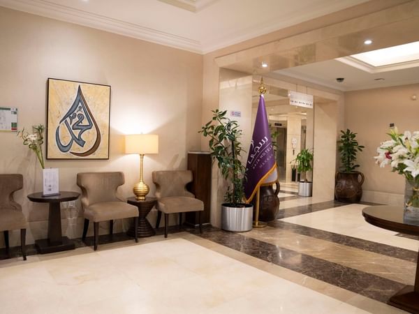 Elegant hotel lobby with chairs, lamps, and artwork at Saja by Warwick Makkah.