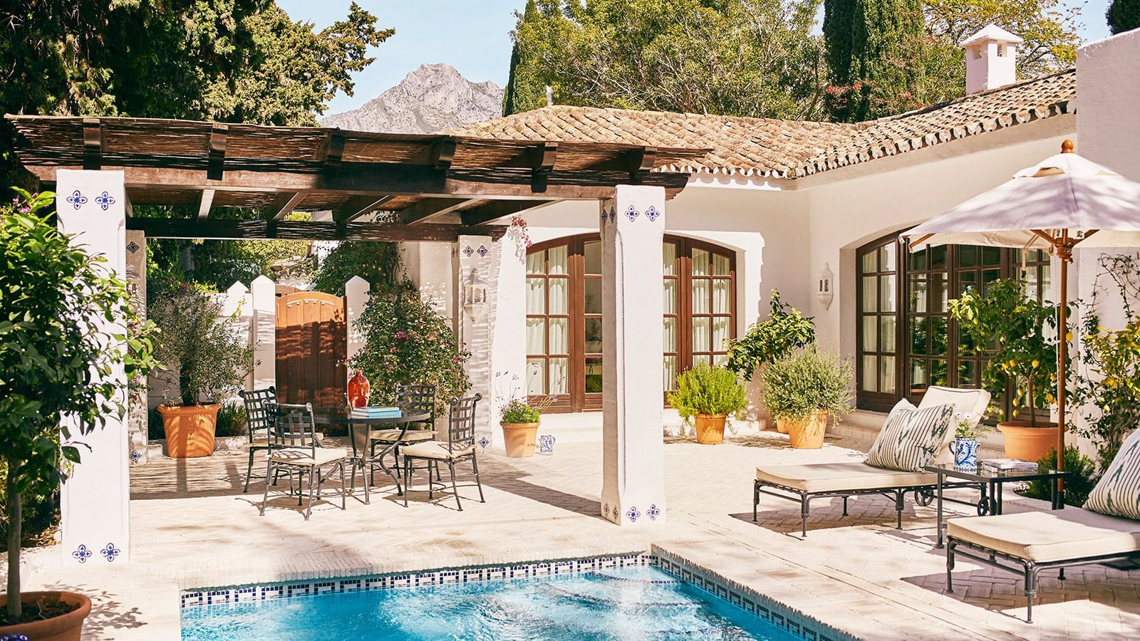 Private patio with lounge chairs and a dining table set by a small swimming pool at the Marbella Club