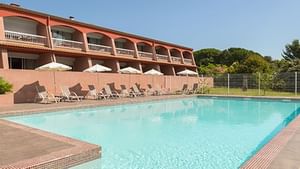 Sunbeds by outdoor pool at Le Mas de Grille