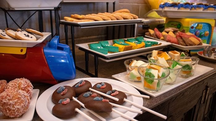 Colorful sweet cakes and chocolate treats on sticks displayed at a dessert buffet in Palmira Cafeteria at Araiza Calafia