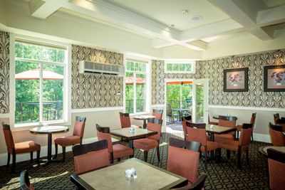 Arranged dining tables in the Garden Room of Plaza Inn & Suites at Ashland Creek​