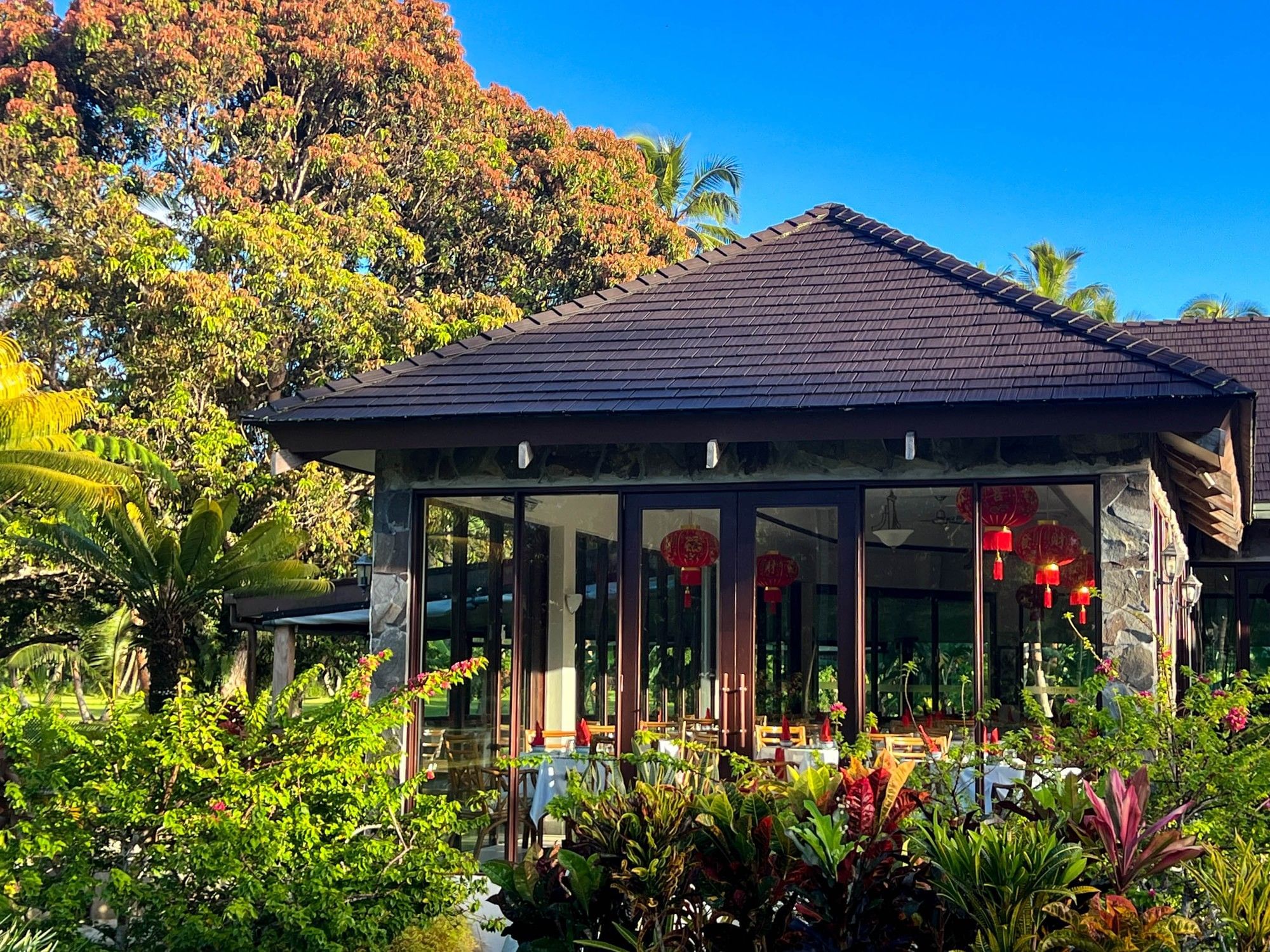The Naviti Resort Fiji Coral Coast building with glass doors, red lanterns, and lush greenery at Coral Coast