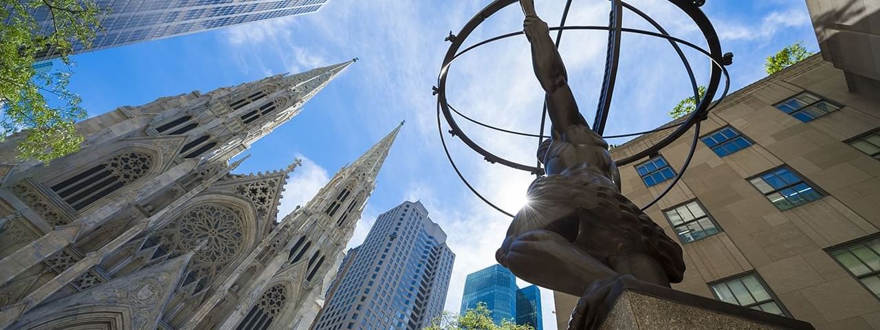 Low-angle view of ATLAS statue with buildings near Warwick New York