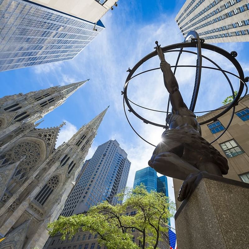 Low-angle view of ATLAS statue with buildings near Warwick New York