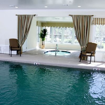 A view of the indoor pool with a shallow end and an adjacent spa at The Pointe at Castle Hill