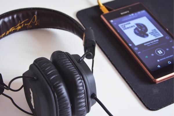 Headphones plugged into phone thats playing music in the workplace