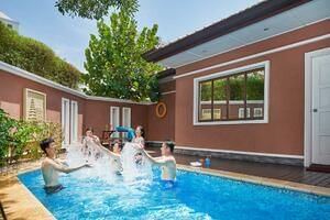 Group of friends enjoying a splash in Premier Suite Pool under sunny skies - Grand Lexis Port Dickson
