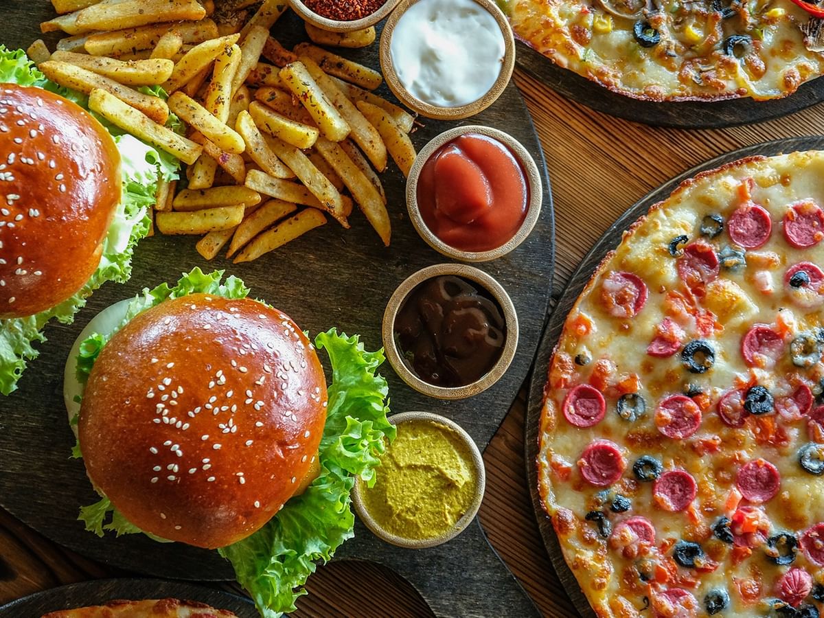 Delicious burgers, fries, and pizzas with condiments at Green Gables Restaurant & Lounge in Whitecourt at Coast Whitecourt Hotel.