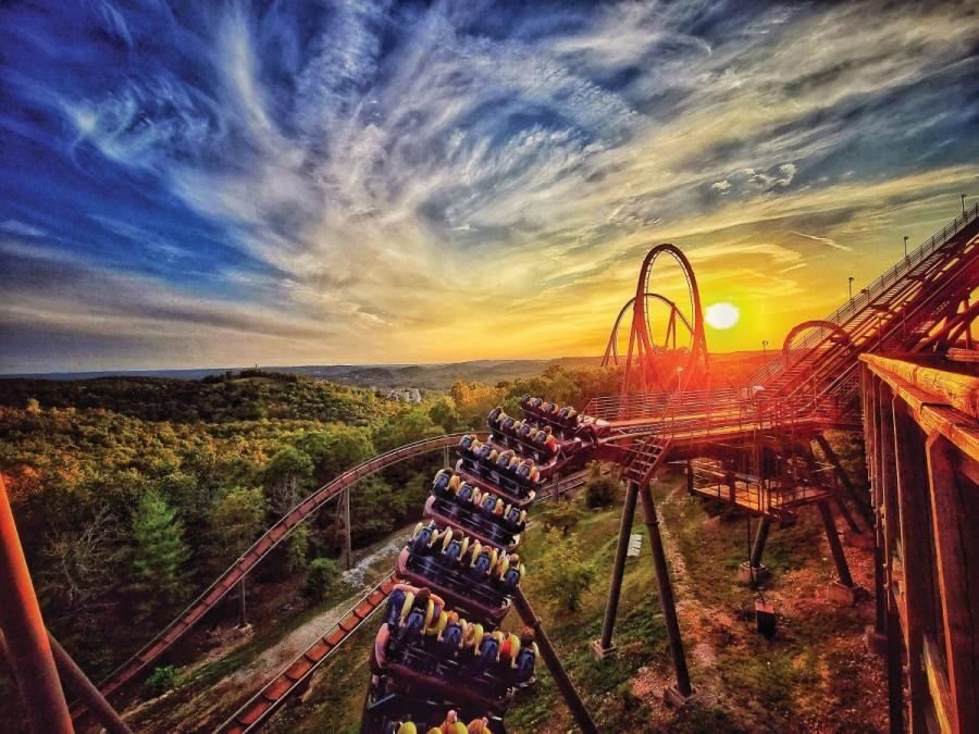 Thrilling roller coaster train descending a track in Silver Dollar City Wildfire against a sunset near Branson Hillside Hotel