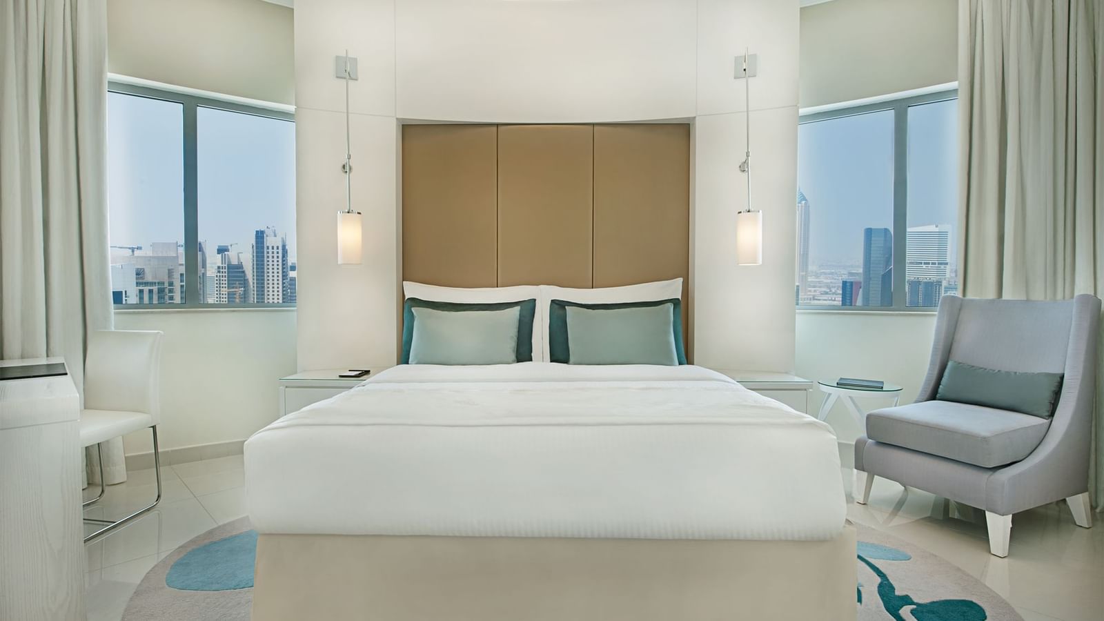 Bed with couch and city view in Deluxe Room at DAMAC Maison Dubai Mall Street