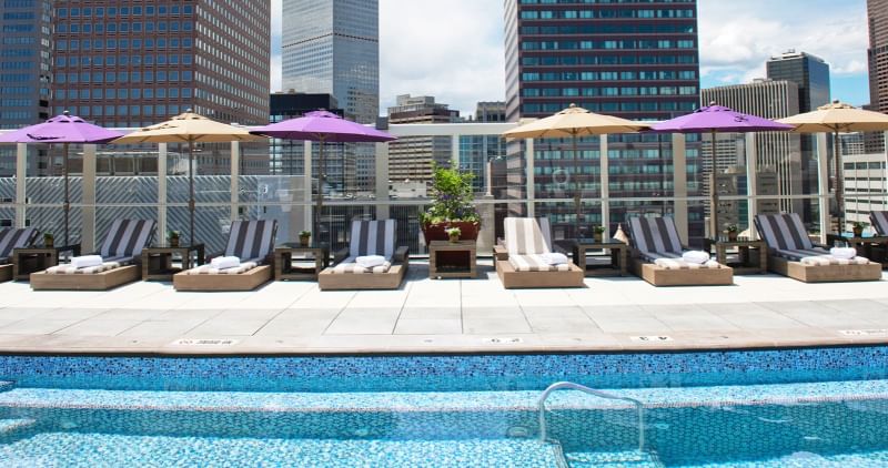 Loungers by the rooftop pool area on a sunny day at Warwick Denver