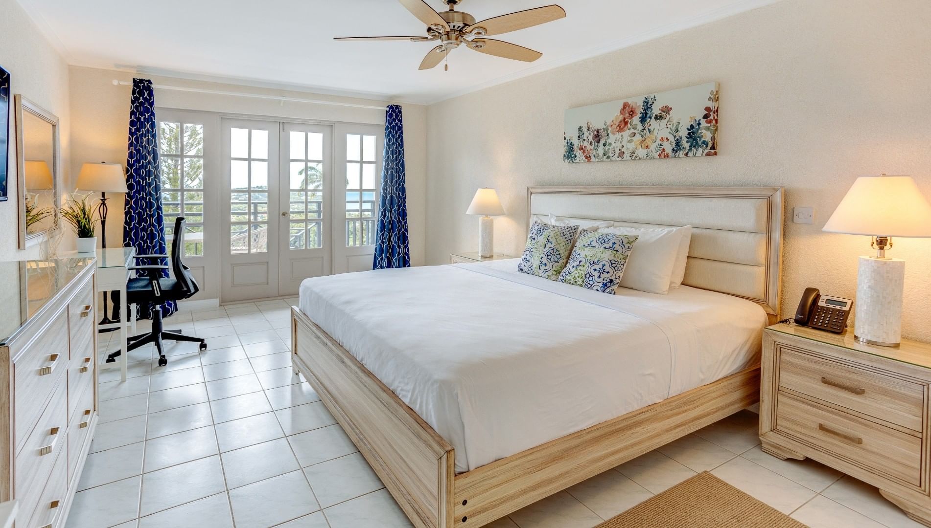 Superior Ocean View Room with a large king bed, desk, ceiling fan, and glass balcony doors to the outside at Bel Jou Hotel
