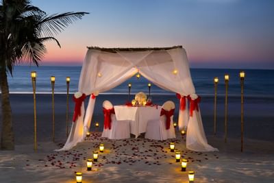 Gazebo set on beach with 2 chairs & candles at Hotel Ajman