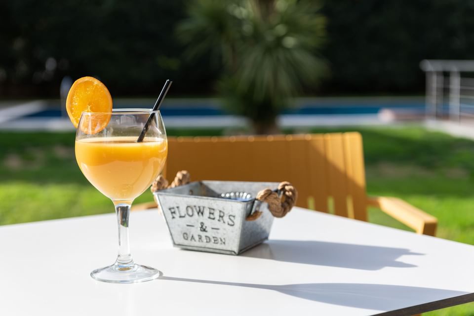 Fresh juice served on an outdoor table by the pool at Hotel Vila Centric