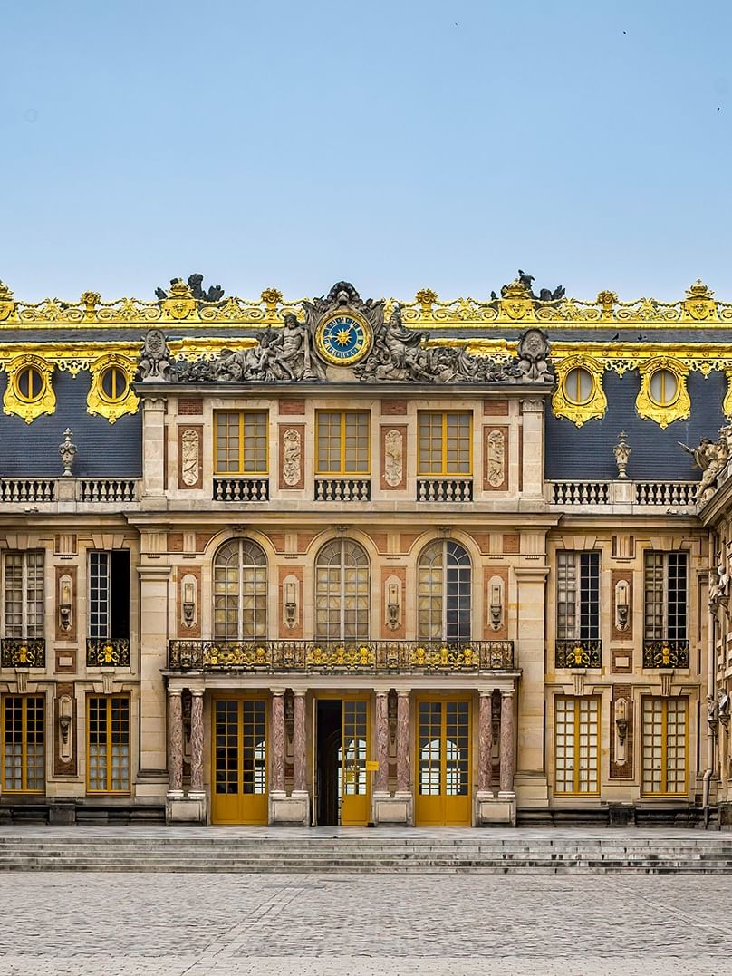 Exterior of the Palace of Versailles with ornate gold detailing near Hotel Westminster Paris