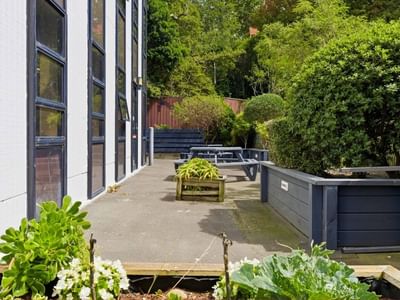 Outdoor seating area with benches and greenery at UniLodge Stafford House.