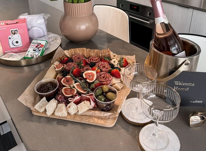 A welcoming spread with a charcuterie board, champagne, and decorative flowers at ReStays Ottawa