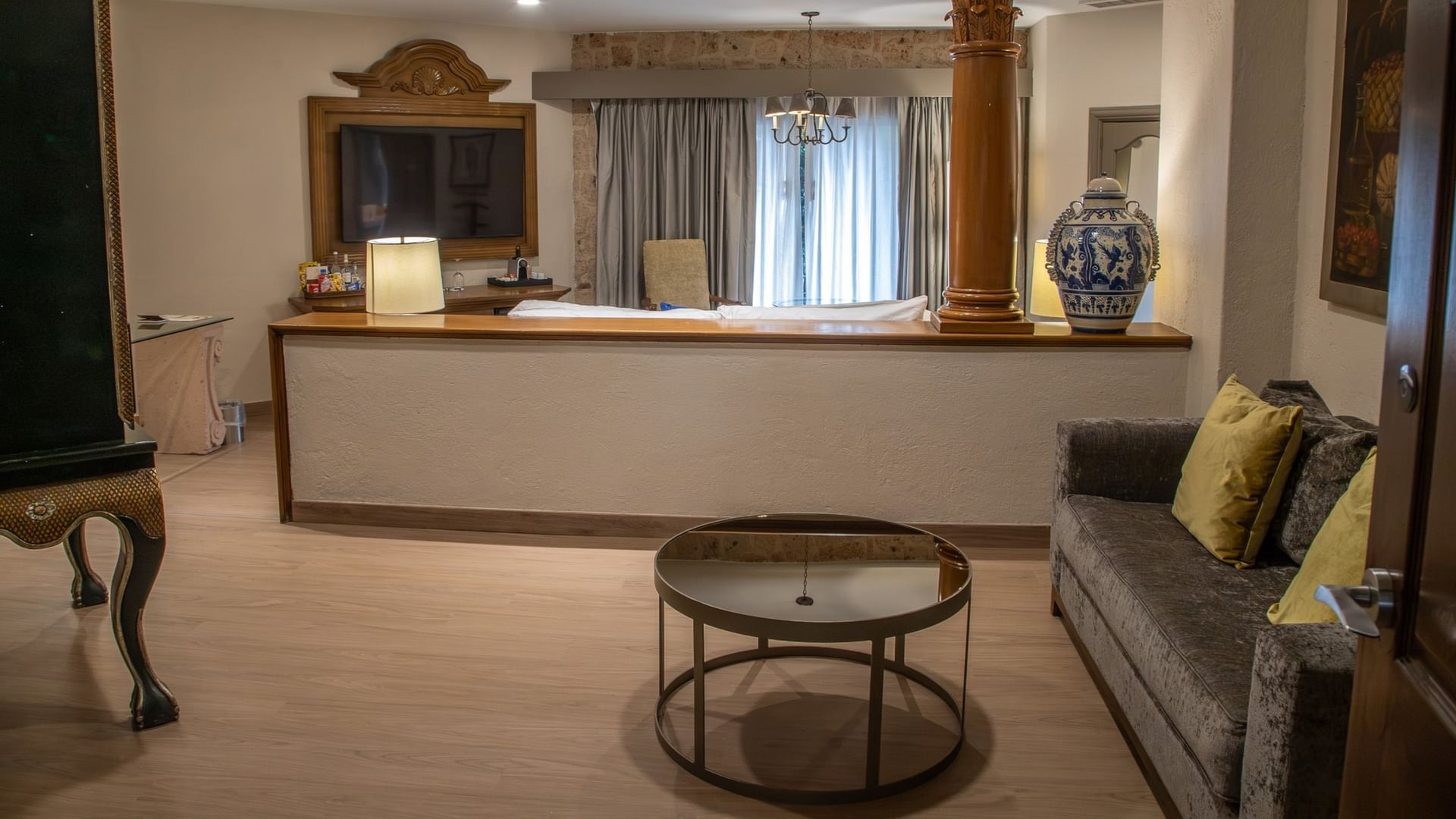 Amplia Master Suite King con sala de estar, mesa de centro redonda y decoración elegante en Quinta Real Guadalajara