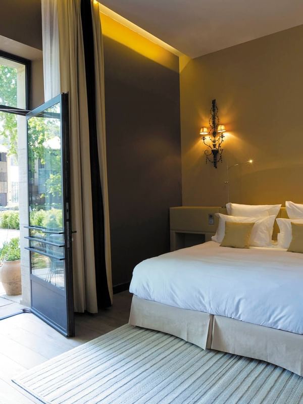 Bed in Junior Suite opened to the garden at Domaine de Manville