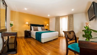 King-size bed, work space & a TV in Superior Room at Le Manoir Bogotá Hotel